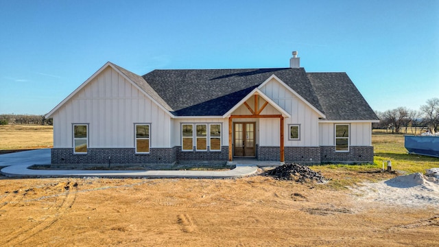 JarTBD Leo Lane, Poolville, TX 76487 - modern inspired farmhouse with brick siding, french doors, a chimney, and board and batten siding