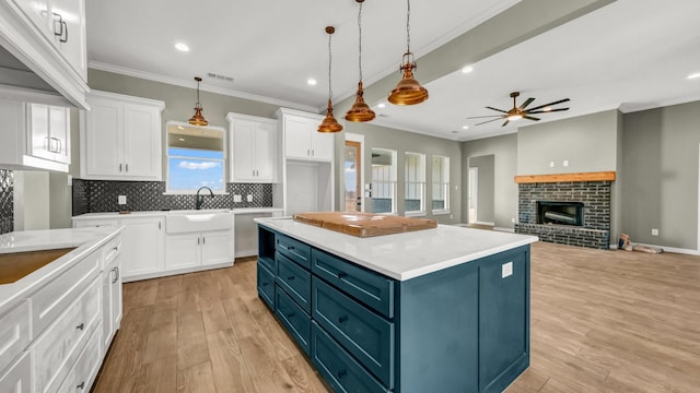 JarTBD Leo Lane, Poolville, TX 76487 - kitchen featuring light wood finished floors, ceiling fan, white cabinets, crown molding, and blue cabinets