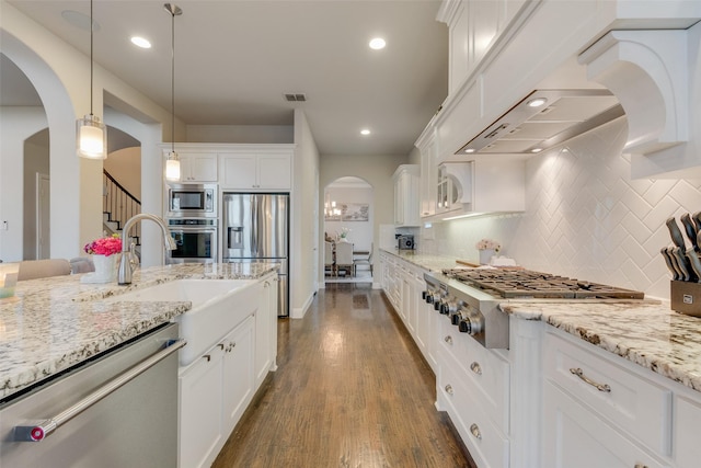 4406 Ravenbank Dr, Rockwall, TX 75087 - kitchen featuring dark wood-style floors, arched walkways, a sink, stainless steel appliances, and white cabinets