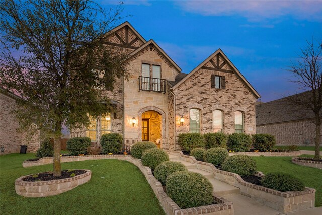 4406 Ravenbank Dr, Rockwall, TX 75087 - view of front of home with a front lawn, a balcony, and brick siding