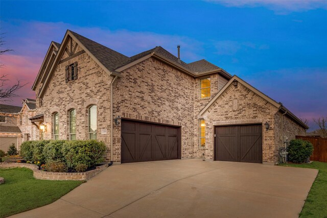 4406 Ravenbank Dr, Rockwall, TX 75087 - french provincial home featuring a garage, brick siding, concrete driveway, and a lawn
