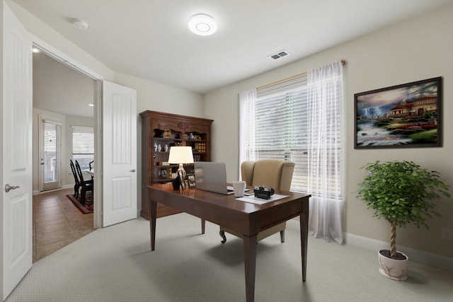 office space featuring visible vents, baseboards, light carpet, and light tile patterned flooring