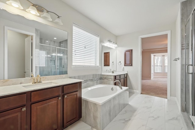 bathroom featuring a shower stall, two vanities, a bath, marble finish floor, and a sink