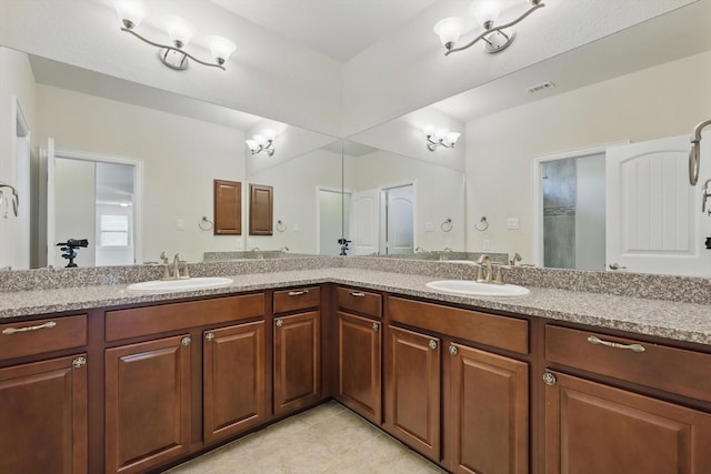 full bathroom featuring double vanity, tile patterned flooring, visible vents, and a sink