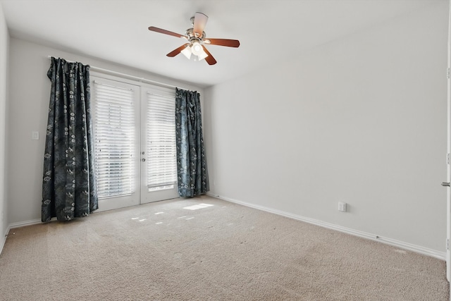 spare room featuring baseboards, a ceiling fan, and carpet