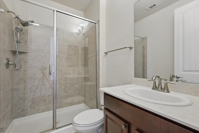 full bath with visible vents, toilet, a stall shower, and vanity