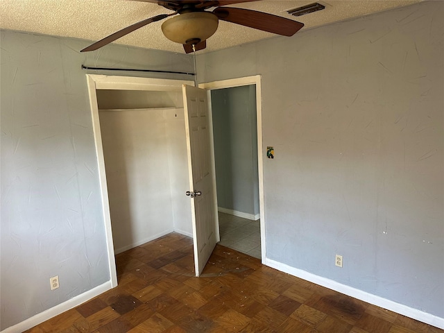 unfurnished bedroom with visible vents, baseboards, a textured ceiling, and a ceiling fan