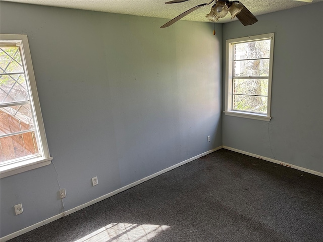 spare room with baseboards, dark carpet, and a textured ceiling