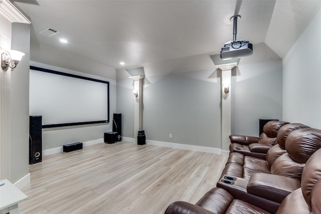 cinema room with decorative columns, visible vents, recessed lighting, and light wood-type flooring