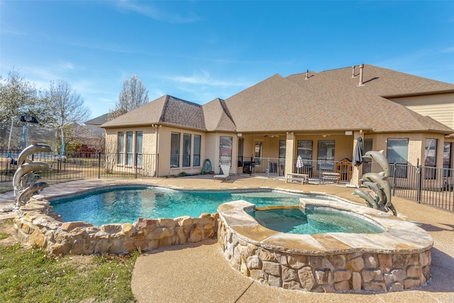 view of pool with a patio, a pool with connected hot tub, and fence