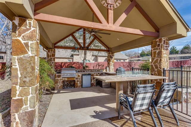 view of patio with area for grilling, exterior kitchen, a gazebo, and a fenced backyard