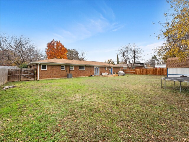 3408 Chaffin Dr, Richland Hills, TX 76118 - view of yard featuring central air condition unit, a trampoline, a fenced backyard, and a gate