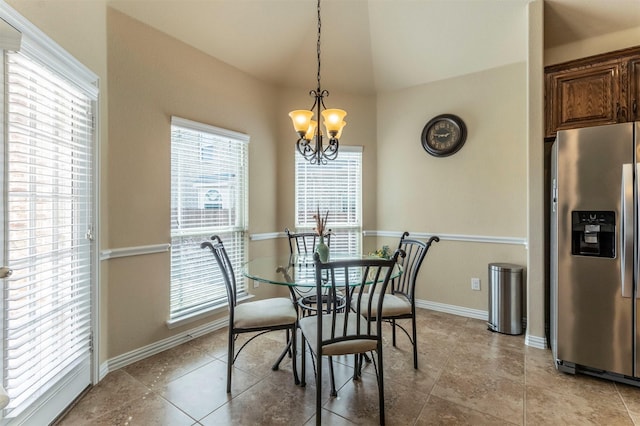 dining area featuring light tile patterned floors, an inviting chandelier, baseboards, and lofted ceiling
