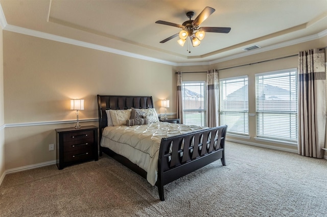 bedroom with a tray ceiling, crown molding, visible vents, and carpet floors
