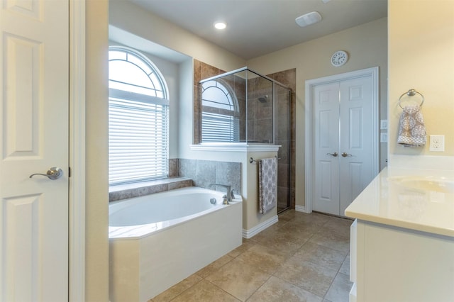 bathroom with vanity, a garden tub, a shower stall, and tile patterned flooring