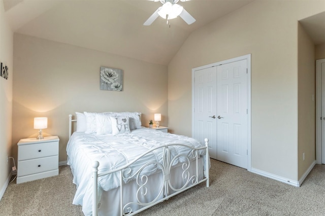 carpeted bedroom with a closet, a ceiling fan, baseboards, and vaulted ceiling