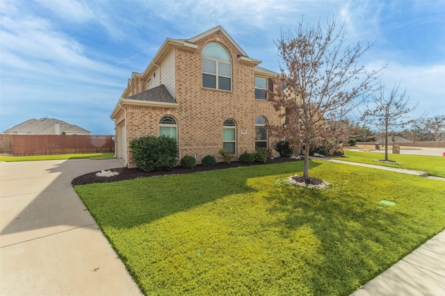 view of front of home featuring brick siding, concrete driveway, fence, and a front yard