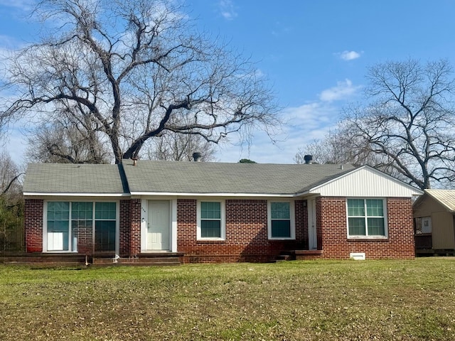 ranch-style house with brick siding, roof with shingles, and a front lawn