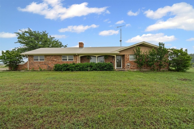 ranch-style home with brick siding, a front lawn, and a chimney