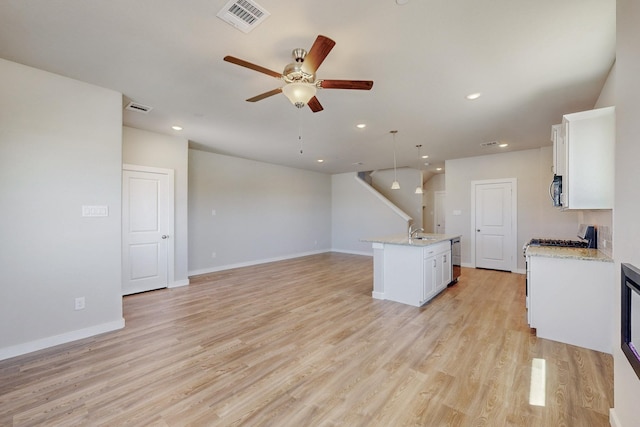 kitchen with a ceiling fan, visible vents, and white cabinetry