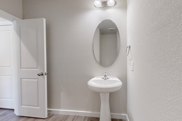 bathroom featuring wood finished floors and baseboards