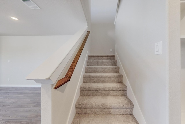 staircase featuring wood finished floors, visible vents, recessed lighting, and baseboards