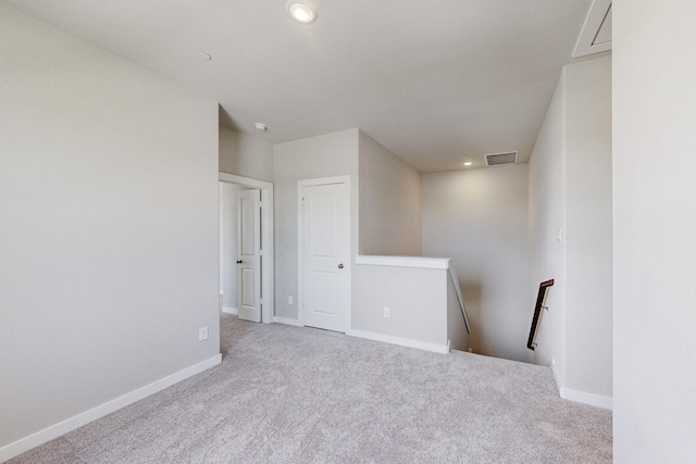 spare room featuring carpet, visible vents, recessed lighting, and baseboards