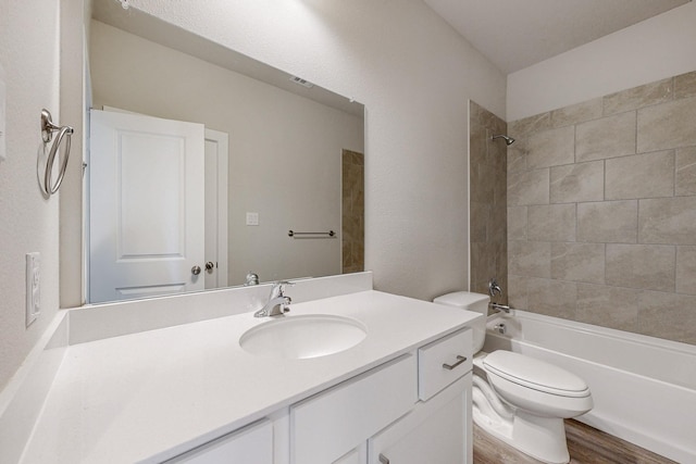 bathroom featuring visible vents, toilet, wood finished floors, vanity, and bathtub / shower combination
