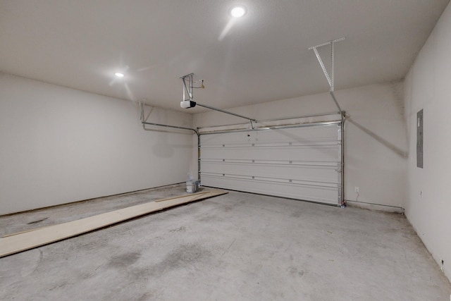 garage featuring recessed lighting, a garage door opener, and electric panel