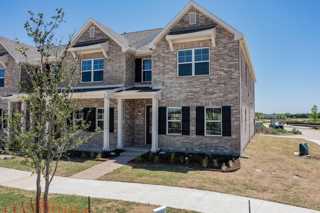 view of front of house with a front lawn and brick siding