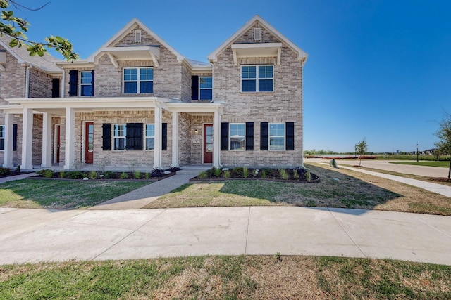 craftsman-style house with a front lawn and brick siding