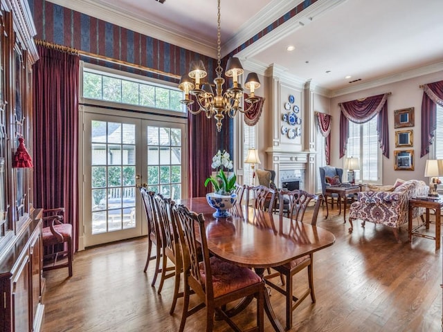 3425 Caleo Ct, Plano, TX 75025 - dining space with a chandelier, wood finished floors, a fireplace, french doors, and ornamental molding