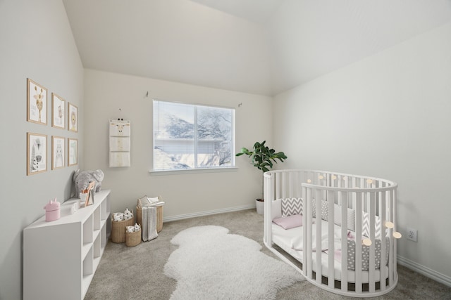 carpeted bedroom with a crib, baseboards, and vaulted ceiling