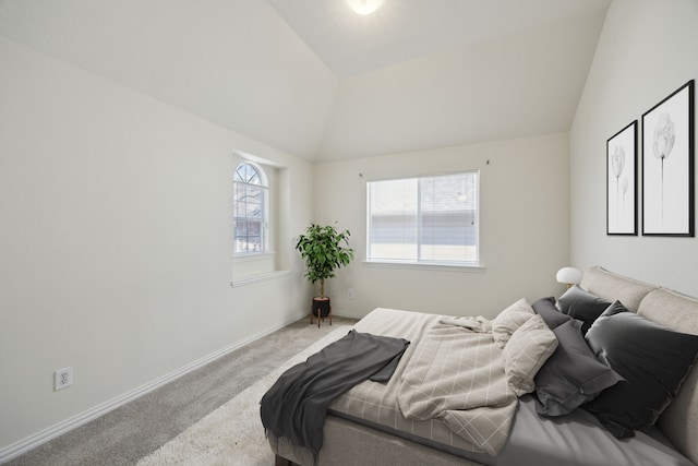 carpeted bedroom with vaulted ceiling and baseboards