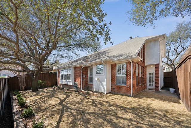 view of front of home featuring brick siding and a fenced backyard