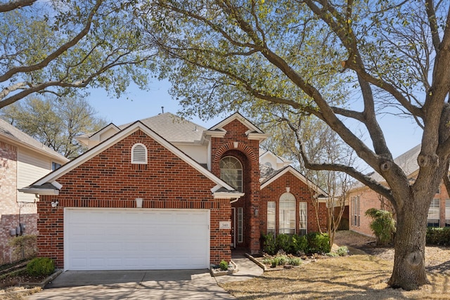 traditional-style house with brick siding, an attached garage, concrete driveway, and roof with shingles