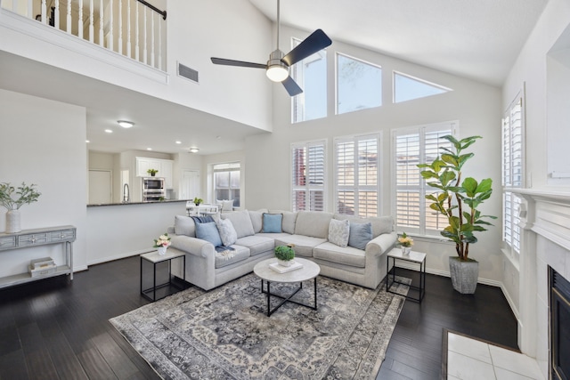 living room with visible vents, a healthy amount of sunlight, ceiling fan, and wood finished floors