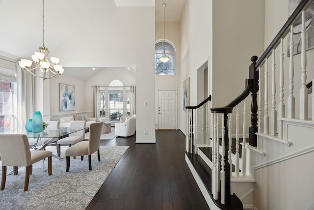 foyer featuring a chandelier, high vaulted ceiling, stairs, and wood finished floors