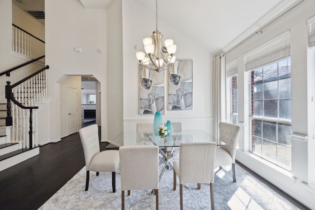 dining space with a notable chandelier, stairway, plenty of natural light, and wood finished floors