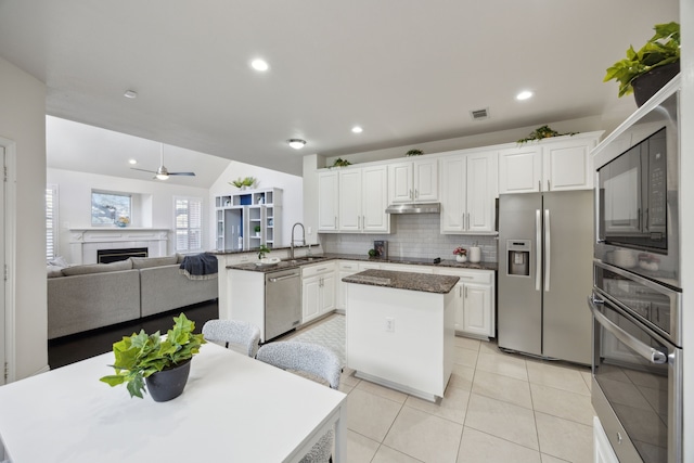 kitchen with visible vents, a center island, a peninsula, black appliances, and a ceiling fan