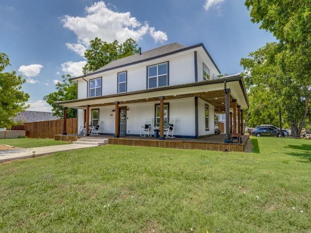 farmhouse featuring a front yard, a porch, and fence