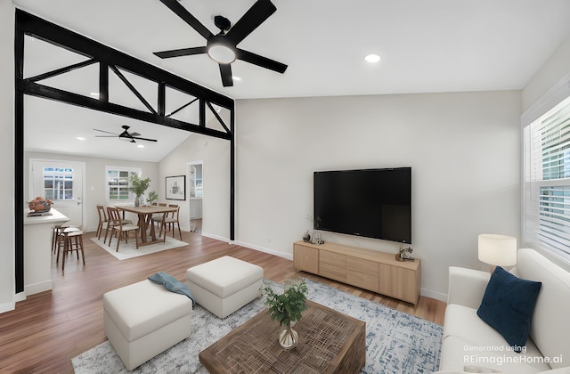 living room featuring ceiling fan, healthy amount of natural light, lofted ceiling, wood finished floors, and baseboards