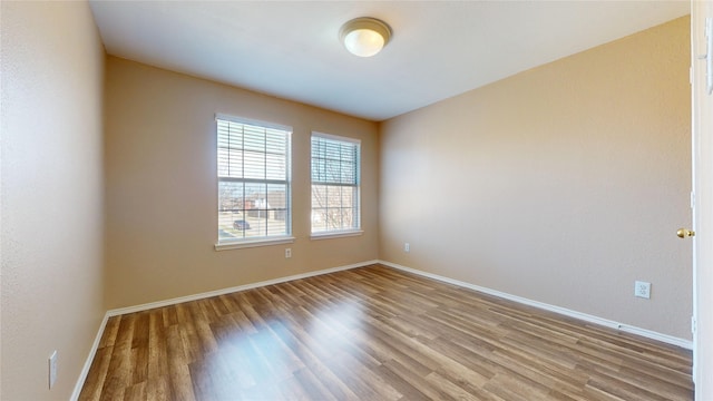empty room with baseboards and wood finished floors
