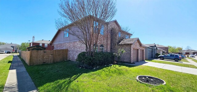 view of side of property with driveway, a lawn, a residential view, brick siding, and fence