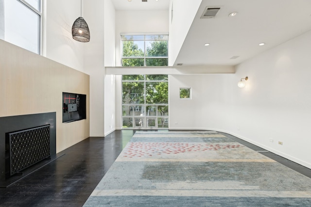 3315 Miro Pl, Dallas, TX 75204 - unfurnished living room with a towering ceiling, wood finished floors, and recessed lighting