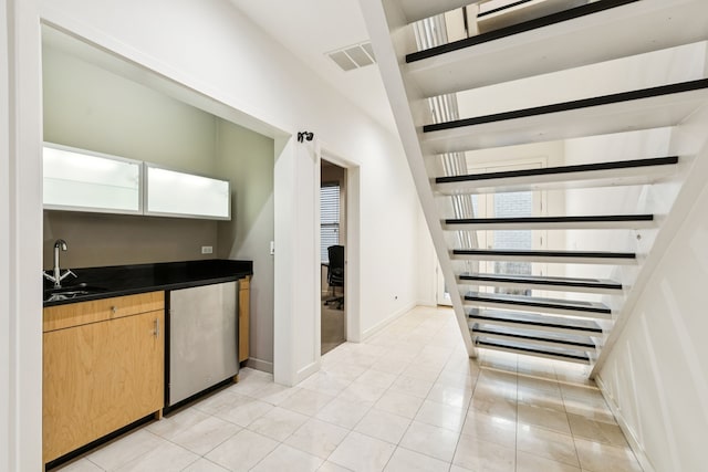 3315 Miro Pl, Dallas, TX 75204 - indoor wet bar featuring fridge, plenty of natural light, stairway, and light tile patterned flooring