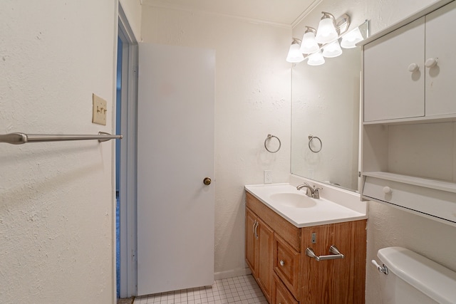 bathroom with a textured wall, tile patterned floors, vanity, and toilet