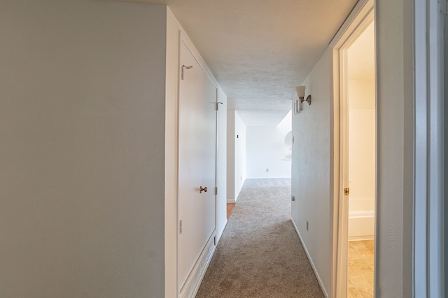 hallway with carpet flooring and baseboards