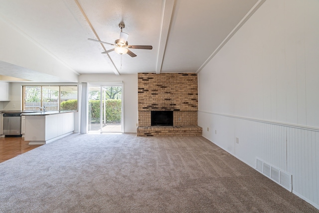 unfurnished living room featuring lofted ceiling with beams, a fireplace, visible vents, ceiling fan, and carpet