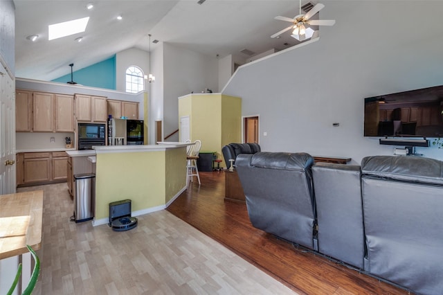 900 Crest Ridge Ct, Irving, TX 75061 - living area featuring high vaulted ceiling, a ceiling fan, light wood-style floors, and a skylight